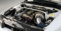 Car engine with turbocharger and 'Nissan' logo on a white background