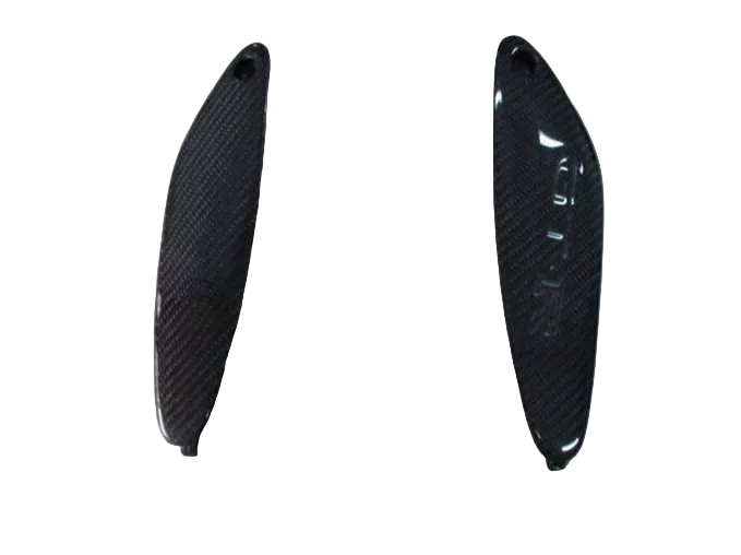 Two carbon fiber car parts on a light gray background